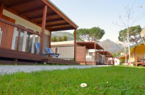 un edificio con un campo de césped delante de él en GLAMPING Italia '90 Experience, en Domaso