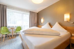 a hotel room with a large bed and a table at Gästehaus Hornegger in Mayrhofen