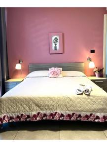 a bedroom with a large bed with two shoes on it at Raggio di Sole in San Cesareo