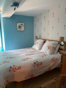 1 dormitorio con 1 cama con flores en la pared en Joli appartement de 60m2 avec Balcon à la campagne, en Courson-les-Carrières