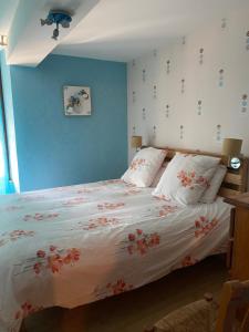 a bedroom with a bed with flowers on the wall at Joli appartement de 60m2 avec Balcon à la campagne in Courson-les-Carrières
