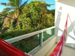 Cayru的住宿－Apto com vista mar no coração de Morro de SP，阳台上的吊床上可欣赏到树林景色