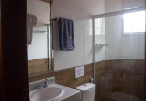 a bathroom with a sink and a toilet and a mirror at Apto com vista mar no coração de Morro de SP in Cayru
