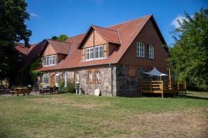 a large brick house with a red roof at Landurlaub auf dem Mellenhof in Funkenhagen