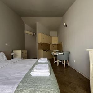 Turquoise Beachside Apartments في دوبروتا: غرفة نوم بسرير وطاولة وكراسي