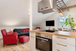 uma cozinha e sala de estar com um fogão e um sofá em Ferienwohnung In Der Weinig em Sasbach am Kaiserstuhl