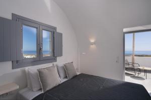 1 dormitorio con cama y vistas al océano en The Vine Suites, en Vourvoúlos