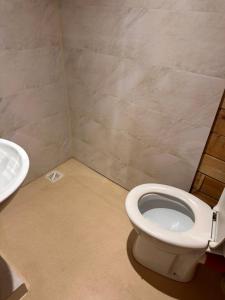 Bungalo في يورمالا: حمام به مرحاض أبيض ومغسلة