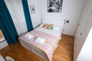 a small bedroom with a bed with a striped blanket at 4u2enjoy in Split