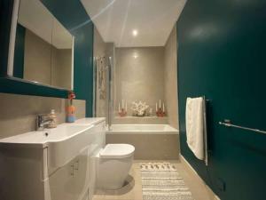 a bathroom with a toilet and a sink and a tub at Georgian Garden Apartment - Central Bath in Bath