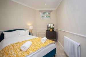 1 dormitorio con 1 cama con 2 toallas en Georgian Garden Apartment - Central Bath, en Bath