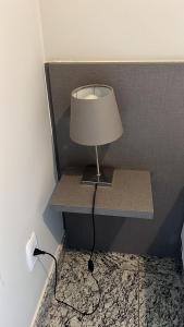 a lamp on a shelf in the corner of a room at Locking's Lourdes 3 in Belo Horizonte