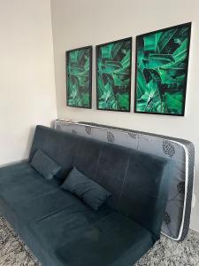 a green couch in a room with three pictures on the wall at Locking's Lourdes 3 in Belo Horizonte