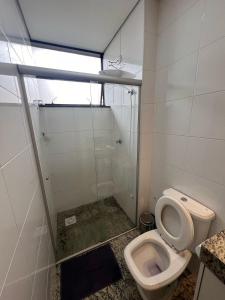 uma casa de banho com um WC e uma cabina de duche em vidro. em Locking's Lourdes 3 em Belo Horizonte
