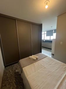 a bedroom with a bed with two towels on it at Locking's Lourdes 3 in Belo Horizonte