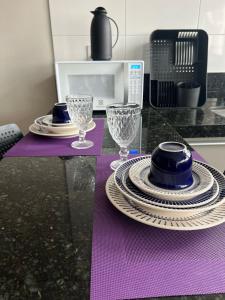 uma mesa roxa com pratos e copos no balcão em Locking's Lourdes 3 em Belo Horizonte