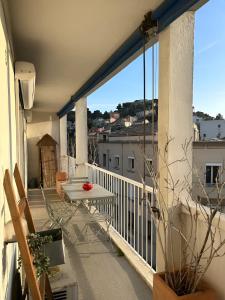 a balcony with a table and a view of a city at Appartement Unique - Roucas Blanc in Marseille