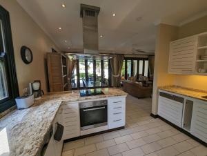 une cuisine avec des comptoirs en marbre et un salon dans l'établissement Maison Bigorno by Simply-Seychelles, à Eden Island