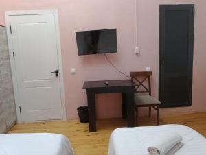 a bedroom with a desk and a tv on the wall at GOLDEN TRIP Hotel in Yunusobod