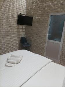 a bedroom with a bed with two towels and a chair at GOLDEN TRIP Hotel in Yunusobod