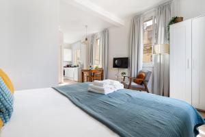 a white bedroom with a bed with towels on it at Lodging Apartments Barceloneta Beach Studio 42 in Barcelona