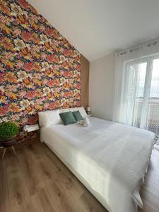 a bedroom with a large bed with a floral wall at Sea La Vie! in Novalja