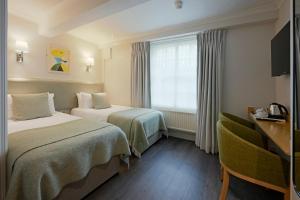 Postel nebo postele na pokoji v ubytování Harlingford Hotel