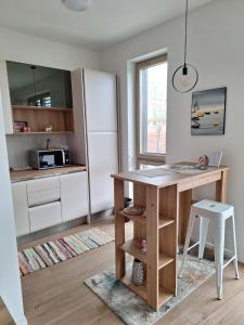 eine Küche mit einem Tisch und einem Kühlschrank in der Unterkunft Aleksandar in Subotica