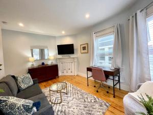 a living room with a couch and a desk at Renovated 4bed 15 Bath, Mit, Harvard,hospitals in Cambridge