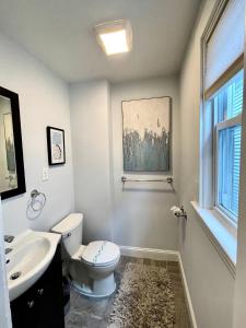 baño con aseo y lavabo y ventana en Renovated 4bed 15 Bath, Mit, Harvard,hospitals, en Cambridge