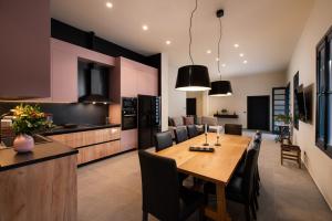 a kitchen and dining room with a wooden table and chairs at Villa Fluvian in Rhodes Town