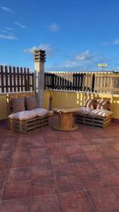 une terrasse avec deux bancs, une table et une clôture dans l'établissement La terrazza, à Tarquinia