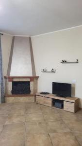 ein Wohnzimmer mit Kamin und Fernseher in der Unterkunft La terrazza in Tarquinia