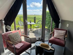 a room with a balcony with chairs and a table at Hotelhuisjes Andijk in Andijk