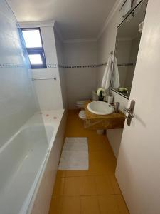 uma casa de banho com 2 WC, um lavatório e uma banheira em São Sebastião l- 5 min from Airport em Santa Cruz - Madeira