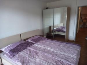 um quarto com uma cama com lençóis roxos e um espelho em Markus Doppler em Salzburgo