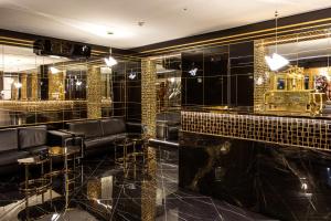 bar z czarnymi i złotymi kafelkami na ścianach w obiekcie Hotel Iskierka Business & Spa w Mielcu