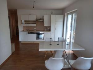 uma cozinha com armários brancos e uma mesa e cadeiras brancas em Markus Doppler em Salzburgo