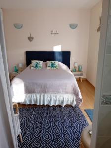 um quarto com uma cama branca e uma cabeceira azul em Cocooning au Saut du Loup em Lavergne