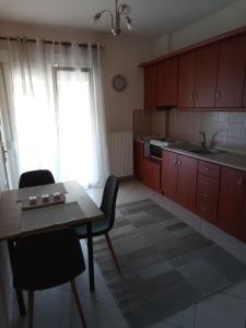 cocina con mesa, sillas y ventana en EvropisHouse en Kozani