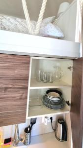 a cupboard with plates and dishes in it at Tivat lovely cosy studio in Tivat