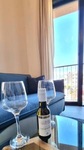 a bottle of wine and two wine glasses on a table at Tivat lovely cosy studio in Tivat