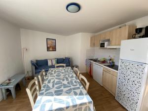 une cuisine et une salle à manger avec une table et un réfrigérateur dans l'établissement Appartement avec piscine - La Chaume, à Les Sables-dʼOlonne 13 autres photos