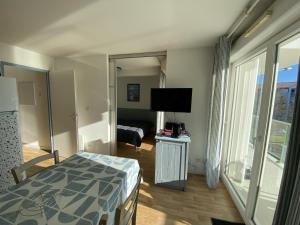 - une chambre avec un lit et une télévision dans l'établissement Appartement avec piscine - La Chaume, à Les Sables-dʼOlonne