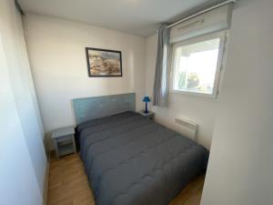 un lit dans une petite pièce avec une fenêtre dans l'établissement Appartement avec piscine - La Chaume, à Les Sables-dʼOlonne