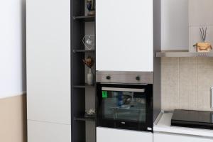 una cocina con estufa y microondas en Dominique Comfort Apartment, en Reggio Calabria
