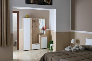1 dormitorio con 1 cama y armario en una habitación en Dominique Comfort Apartment, en Reggio Calabria