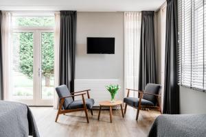 1 dormitorio con 2 sillas, mesa y TV en de Logerie en Enkhuizen