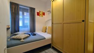a small bedroom with a bed and a window at Town Square Apartment in Braşov