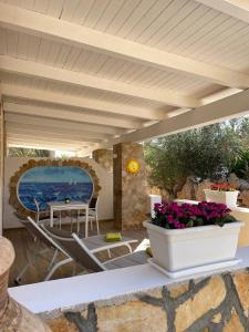 patio ze stołem, krzesłami i kwiatami w obiekcie B&B SoleLuna w mieście Lampedusa